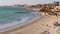 People enjoy warm weather Mediterranean Sea surf at the Cabo Roig sandy beach at winter time. Mediterranean sea