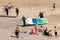 People enjoying the beach, stand up paddleboarders with board. Cullercoats Bay, North Tyneside, UK