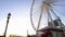 People enjoying leisure in crowded theme park, huge observation wheel rotating