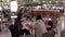 People enjoying meal in modern mall food court cafeteria.