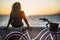 People enjoying outdoor leisure actvity looking a beautiful coloured sunset - woman with long curly blonde hair viewed from back
