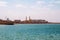 People are enjoying a sunny day on a beach in Ras Al Khaimah. Minaret in background, UAE