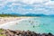 People enjoying the sunny weather on the beach at Byron Bay, NSW, Australia