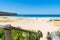 People enjoying the sunny weather at Pebbly Beach, a popular camping area with great surfing beach and bush walks within