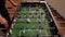 People enjoying table soccer game. Close up of table football kicker game