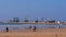 People enjoying the walk on popular beach Tagharte at the windy Atlantic Ocean with jacked fishing boats.