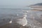 People enjoying warm sunny day in the water on a beach in Cromer, Norfolk, UK