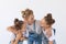 People, family and children concept - portrait of a lovely mother embracing her twin daughters on white background