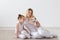 People, family and pets concept - mother and daughter sitting on the floor with puppy Jack Russell Terrier