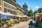 People at farmer market on Barenplatz square and Bundeshaus federal building in background in Bern old town Switzerland