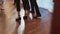 People feet are actively dancing and jumping on old wooden floor, close-up.