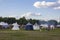 People at the festival of medieval culture with tents and bonfires in the green forest on the background of the modern city