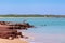 People fishing from the coast. Land based fishing, anglers catching fish barramundi. Rocky shore. Vivid colors. Dundee Beach