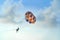 People flying in a colorful parachute or parasail together with blue sky and clouds in freedom and travel concept