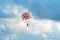 People flying in a colorful parachute or parasail together with blue sky and clouds in freedom and travel concept