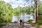 People on the forest lake walking path. Wilderness sustainable living concept