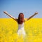 People freedom success concept. Happy woman in the field with flowers at sunny day in the countryside. Nature beauty background,