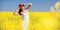 People freedom success concept. Happy woman in the field with flowers at sunny day in the countryside. Nature beauty background,