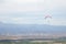 People gliding using a parachute on the background of the blue sky