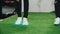 People in glowing sneakers jump on artificial grass closeup