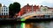 People going by famous Ha Penny Bridge in Dublin, Ireland during the evening