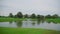 People on golf course amidst water, natural landscape. Wide footage