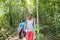 People Group With Backpacks Trekking On Forest Path, Young Men And Woman On Hike