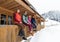 People Group Sitting On Terrace Wooden Country House Winter Snow Resort Cottage
