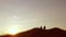 People group of tourists walking on top of a travel sunset silhouette mountain. Slow video tourists people group go