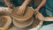 People, hands and clay on spinning table in pottery for bowl, vase or ceramics in creativity, art or shape at workshop