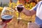 People and Hands with glasses of red wine in the frame. Picnic at sunset in the hills of Italy. Vineyards and open nature in the