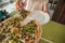 People hands taking slices of pizza. Table with pizza in a restaurant. Pizza and hands close up on a green