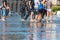 People having fun in a mirror fountain in Bordeaux, France