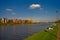 People having sunbath and rest at the bank of Main river with new living buildings in construction in downtown of Frankfurt,