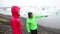 People in heavy rain. Iceland hiking couple by Jokulsarlon glacial lagoon glacier lake walking in hardshell jackets in