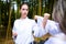 people high kicks during training of taekwondo outdoors bamboo background