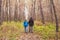 People, hike, adventures, tourism and nature concept - Young woman and man walking in forest with backpack