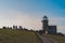 People hiking to the Belle Tout lighthouse on top of Seven Sisters, Clifftop Paths Nature Reserve. South of England