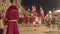 People in historical costumes walk on street carrying flags