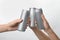 People holding aluminum cans on white, closeup. Space for design