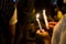 People holding candle vigil in darkness seeking hope, worship, p