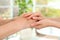 People holding hands together on blurred background. Help and elderly care concept