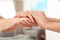 People holding hands together on blurred background. Help and elderly care concept