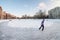 People iceskating on cleared ice of frozen lake in residential area of city, the St. Petersburg, Russia