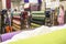 people inside of traditional fabric store with stacks of colorful textiles