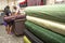 people inside of traditional fabric store with stacks of colorful textiles