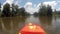 People kayaking on lake with sunshine wearing life vest