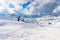 People kite siiking in a snowy slope with majestic mountain peaks in backgroud