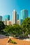 People at Kowloon Park and skyline of buildings at tsim sha tsui