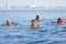 People in lifejackets swimming in open sea